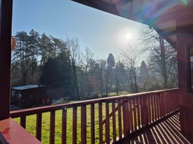 A view of trees and grass from a deck with sunlight at the property in Builth Wells