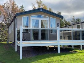 A cabin with a deck and a door at location 12 in a wooded area