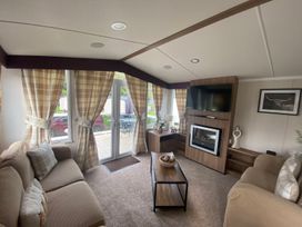 A living room with a sofa and television at The Old Barn in Manchester