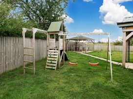 A play structure with swings and a bench in a garden