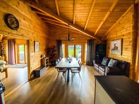 A dining room with a table and chairs at a wooden house in unspecified location