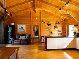 A living room with a sofa and a kitchen counter at The Lodge in the Woods