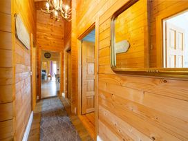 A hallway with wooden walls and a chandelier at The Old Barn in Manchester