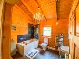 A bathroom with a bathtub, toilet, and sink at The Old Barn in Manchester