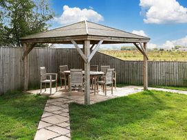 A gazebo with a table and chairs in a garden
