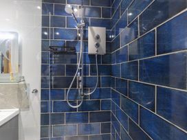 A bathroom with blue tiled walls and a shower at 1Bed Coastal Retreat Sleeps 2 Parking Wifi Bude