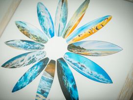 A circular arrangement of surfboard art pieces featuring beach and ocean images at 1Bed Coastal Retreat Sleeps 2 Parking Wifi Bude