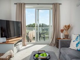 A living room with a television and balcony access at Spacious 3 Bed House Sleeps 6 Parking Wifi in Newquay