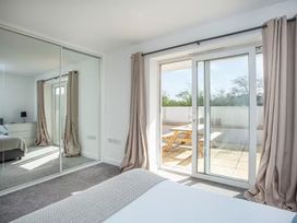 A bedroom with a mirror and sliding door leading to a patio at Spacious 3 Bed House Sleeps 6 Parking Wifi, Newquay
