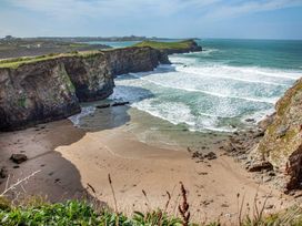 A beach with cliffs and waves at a coastal area in Newquay