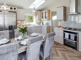 A kitchen with a dining table and chairs at 2Br Lodge Pool Fireplace PetsOK Parking in Goonhavern