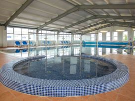 An indoor pool area with a jacuzzi and lounging chairs at 2Br Lodge Pool Fireplace PetsOK Parking Goonhavern