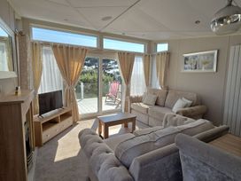 A living room with a sofa and a TV at 2Br Lodge Pool Fireplace PetsOK Parking in Goonhavern