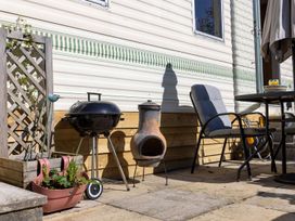 An outdoor area with a barbecue grill and outdoor furniture at Coastal Hideaway in Cornwall Dog Friendly Goldsithney