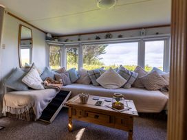 A snug with a sofa and table at Coastal Hideaway in Cornwall Dog Friendly Goldsithney