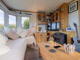 A snug with a sofa, coffee table, and television at Coastal Hideaway in Cornwall Dog Friendly Goldsithney