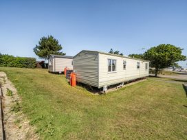 A static caravan with gas cylinders in a grassy area at 3 Bed Sleeps 8 Sea View Pets Parking Reighton Gap near Filey