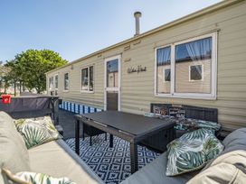 A mobile home with patio furniture at Willows Retreat in Reighton Gap near Filey