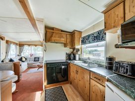 A kitchen and living area with a sofa and dining table at 3 Bed Sleeps 8 Sea View Pets Parking Reighton Gap near Filey
