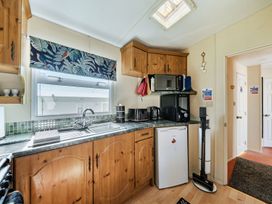 A kitchen with cabinets, sink, and appliances at 3 Bed Sleeps 8 Sea View Pets Parking Reighton Gap near Filey