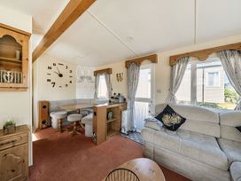 A living room with a sofa and dining table at 3 Bed Sleeps 8 Sea View Pets Parking Reighton Gap near Filey