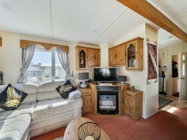 A living room with a television and sofa at 3 Bed Sleeps 8 Sea View Pets Parking Reighton Gap near Filey