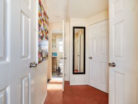 A bathroom corridor with multiple doors and a mirror at 3 Bed Sleeps 8 Sea View Pets Parking in Reighton Gap near Filey