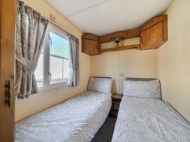 A bedroom with twin beds and a window at 3 Bed Sleeps 8 Sea View Pets Parking Reighton Gap near Filey