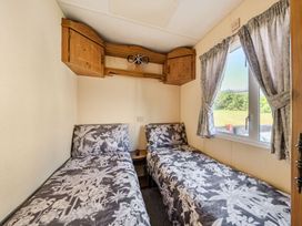 A bedroom with two beds and a window at 3 Bed Sleeps 8 Sea View Pets Parking in Reighton Gap near Filey