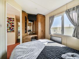 A bedroom with a bed and wardrobe at 3 Bed Sleeps 8 Sea View Pets Parking Reighton Gap near Filey