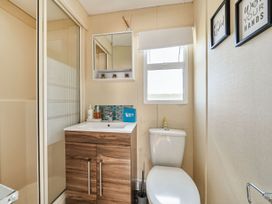 A bathroom featuring a shower, sink, toilet, and a window at 3 Bed Sleeps 8 Sea View Pets Parking Reighton Gap near Filey