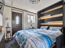 A bedroom with a bed and side table at Studio Sleeps 2 with Parking and Garden Trewidland near Liskeard