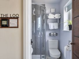 A bathroom with shower, toilet, towels, and a small plant at Studio Sleeps 2 with Parking and Garden Trewidland near Liskeard