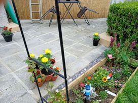 A garden with flower pots and a table with chairs at Studio Sleeps 2 with Parking and Garden Trewidland near Liskeard