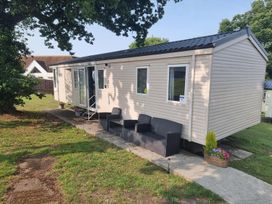 A mobile home with seating and a pathway at Chalet Sleeps 6 swimming pool Thorness Bay