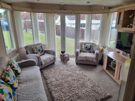 A snug with sofas and a television at Chalet Sleeps 6 swimming pool Thorness Bay