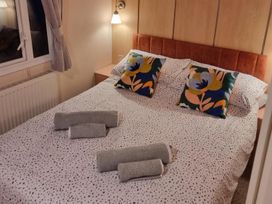 A bedroom with a bed and decorative pillows at Chalet Sleeps 6 swimming pool Thorness Bay
