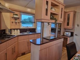 A kitchen with cabinets and appliances at Chalet Sleeps 6 swimming pool Thorness Bay