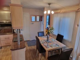 A dining room with a table and chairs at Chalet Sleeps 6 swimming pool Thorness Bay