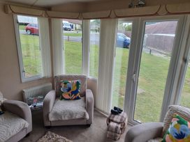 A snug with windows and seating at Chalet Sleeps 6 swimming pool Thorness Bay