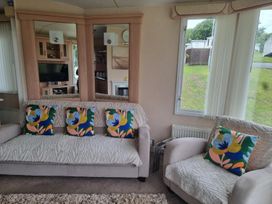 A living room with a sofa and armchair at Chalet Sleeps 6 swimming pool Thorness Bay