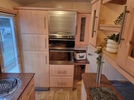 A kitchen with cabinets and appliances at Chalet Sleeps 6 swimming pool Thorness Bay