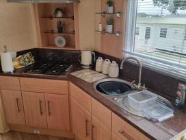 A kitchen with a sink and gas stove at Chalet Sleeps 6 swimming pool Thorness Bay