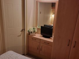 A bedroom with a dresser and television at Chalet Sleeps 6 swimming pool Thorness Bay