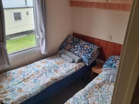 A bedroom with twin beds and a window at Chalet Sleeps 6 swimming pool Thorness Bay