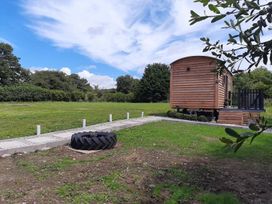 An outdoor area with a wooden cabin and a tire at Min yr Afon Cabin Sleeps2 Hot Tub Parking in Gwalchmai