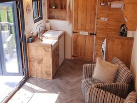 A kitchen with wooden cabinets and a sink at Min yr Afon Cabin Sleeps2 Hot Tub Parking in Gwalchmai