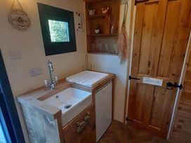 A sink with cabinet and refrigerator at Min yr Afon Cabin Sleeps2 Hot Tub Parking Gwalchmai