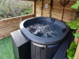 A hot tub in an outdoor area at Min yr Afon Cabin Sleeps2 Hot Tub Parking in Gwalchmai