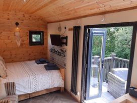 A bedroom with a bed and TV at Min yr Afon Cabin Sleeps2 Hot Tub Parking in Gwalchmai